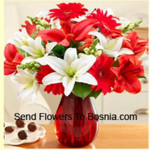 빨간 거베라, 흰 백합, 빨간 백합 등 다양한 꽃이 아름답게 유리병에 배열되어 있습니다