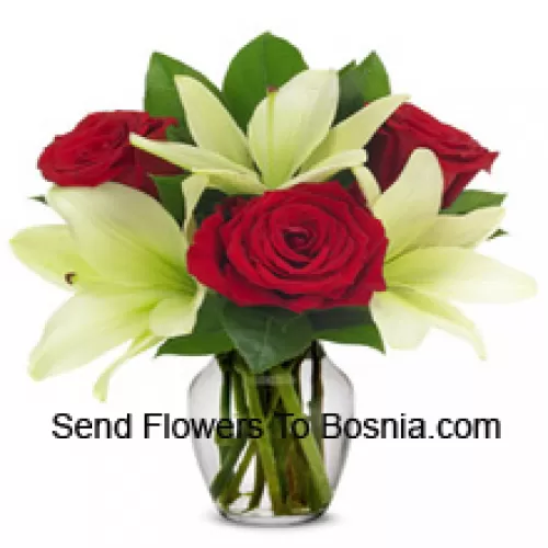 ガラス製の花瓶に季節のフィラーを加えた赤いバラと白いユリ
